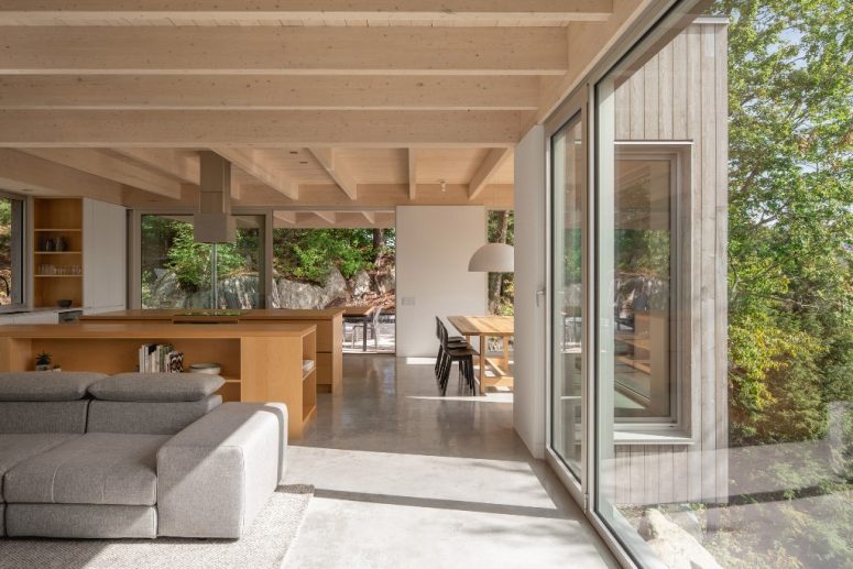 The main space is an open layout with a dining space, a kitchen and a living room, the furniture is simple and minimal