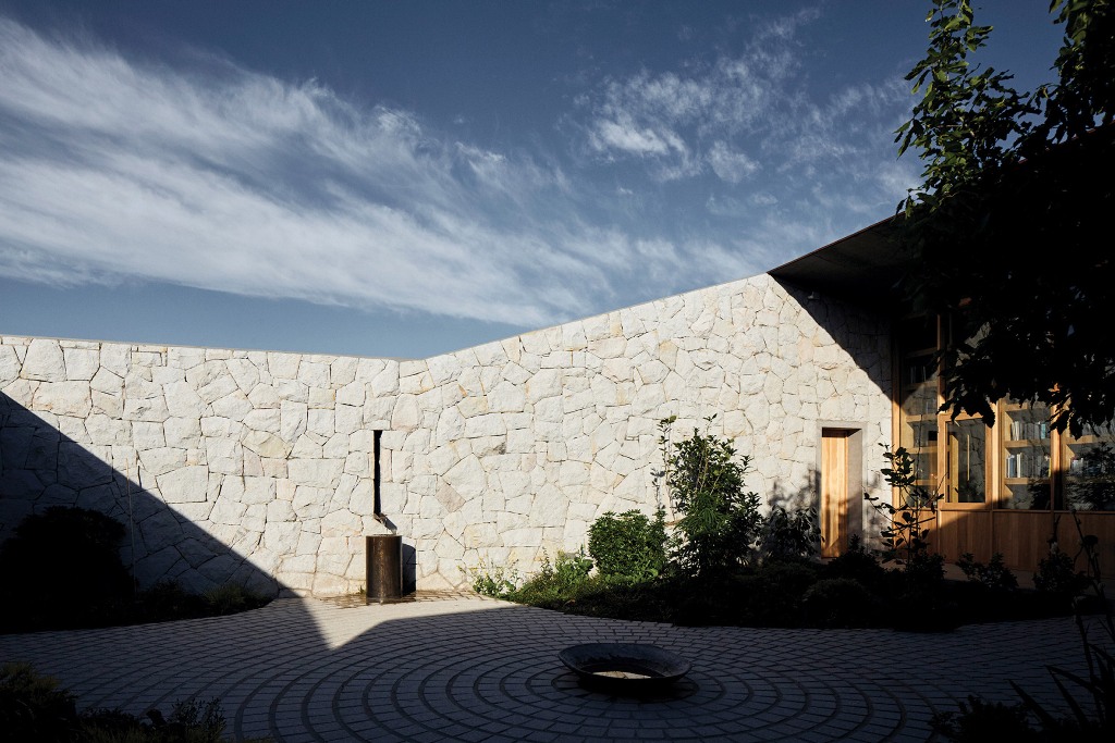 The courtyard shows off a fire pit and a water butt plus some greenery