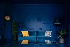 a moody navy living room design with an yellow pillow
