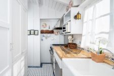 an all-white kitchen design with touches of natural wood