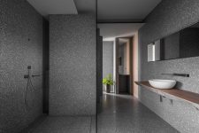 07 The bathroom is clad with grey terrazzo and features some wood to soften it