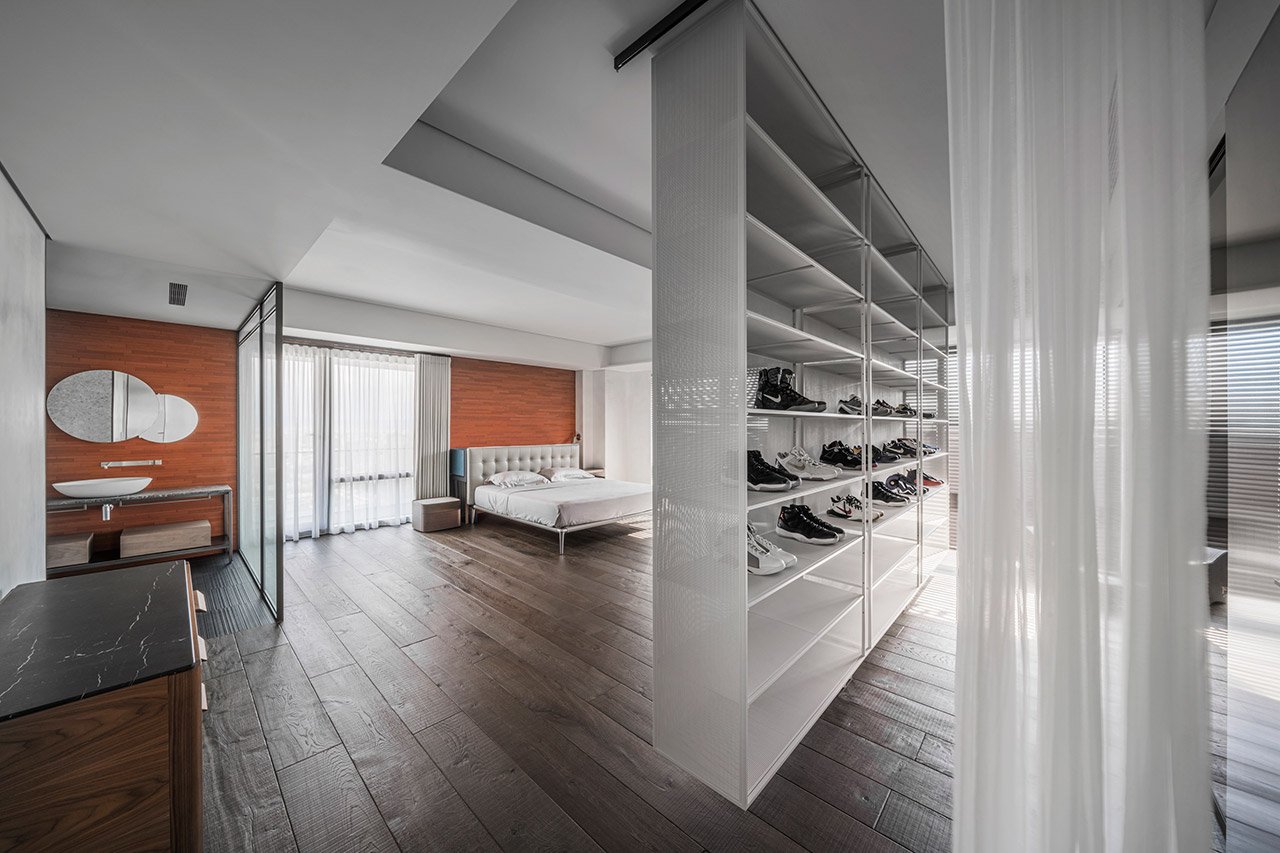 Another bedroom is also combined with a bathroom, and a wall with trainers is a space divider