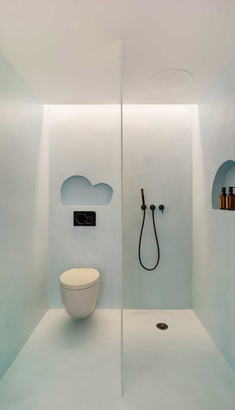 Inside the doors there's a space in light blue with a shower space and a toilet