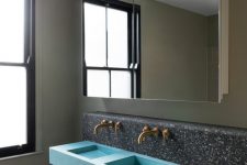 08 The bathroom is done wiht dark terrazzo tiles, a blue double sink