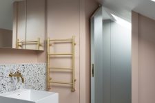 09 The second bathroom shows off neutral terrazzo, a floating sink and blush walls