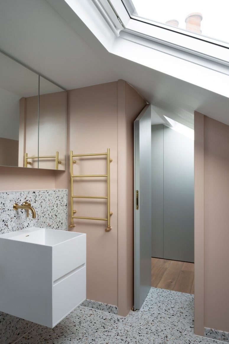 The second bathroom shows off neutral terrazzo, a floating sink and blush walls