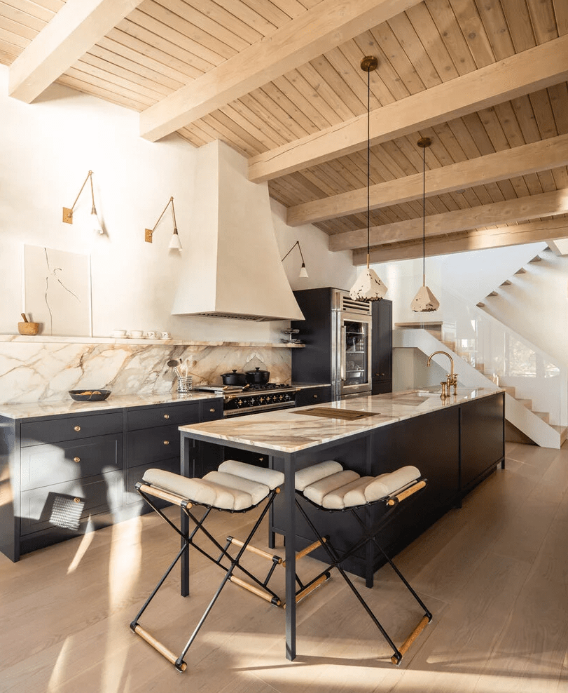 A wooden ceiling paired with a marble backsplash and coutnertops, geometric lamps and catchy stools add interest here