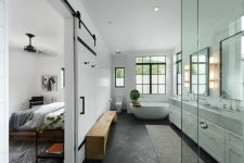 10 The master suite has a large and stylish bathroom with large windows and a sliding barn door