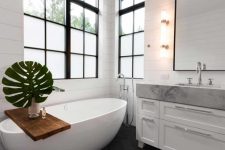 11 An oval soaking tub is placed at the far end of the bathroom, where it’s framed by both windows