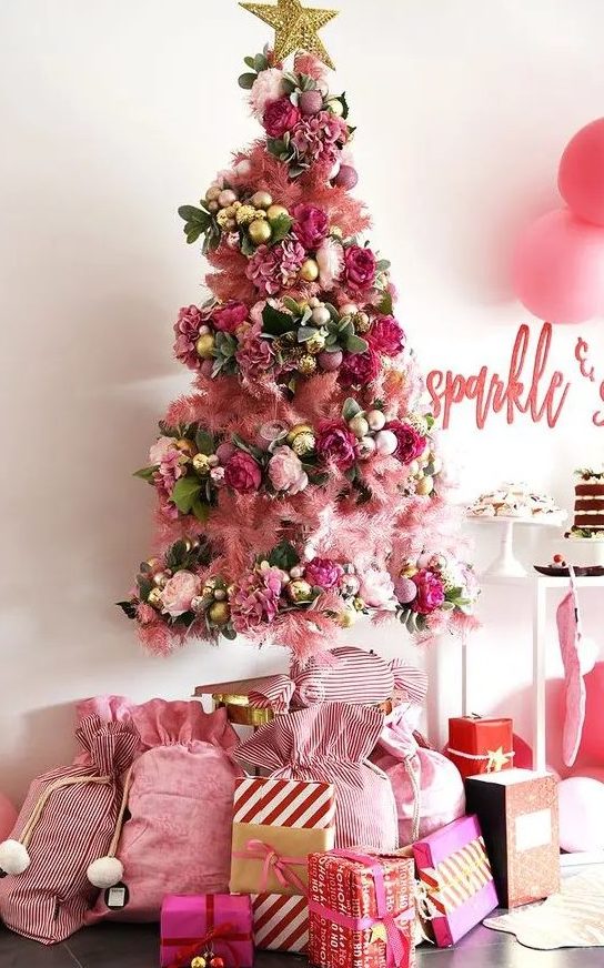 a beautiful and super glam pink Christmas tree with pink, fuchsia, gold ornaments, leaves and a lovely gold star tree topper