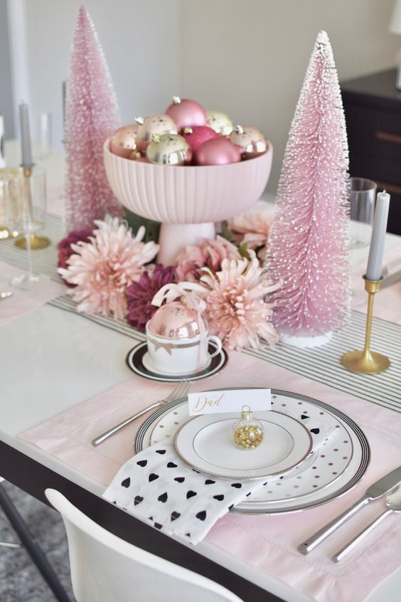 a glam pink Christmas table setting with pink and printed tiles, a pink ornament centerpiece, bottlebrush trees and blooms