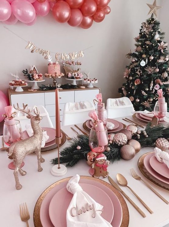 a glam pink Christmas tablescape with pink porcelain, copper cutlery, gold deer and pink ornaments and candles