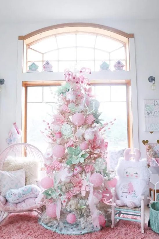 a neutral Christmas tree decorated with pink and pastel green ornaments, candy canes, faux blooms and cupcakes is amazing