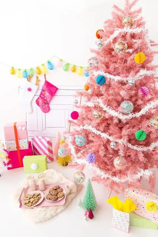 a pastel pink Christmas tree with colorful paper and glass Christmas ornaments and white garlands is a colorful modern solution