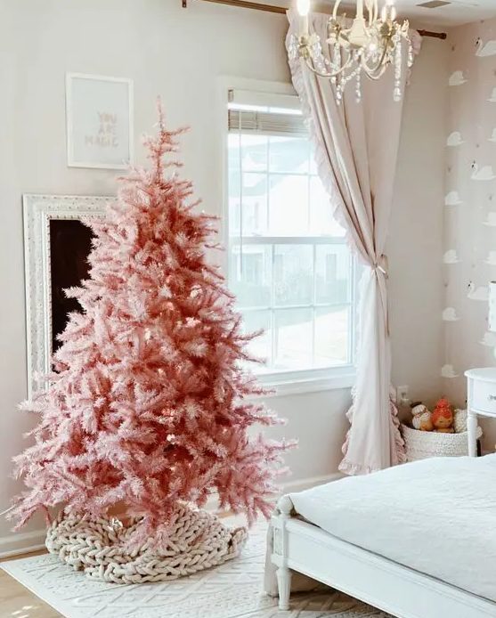 a pink Christmas tree with no decor at all but a chunky knit cover for the base is an awesome idea for modern spaces