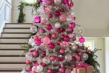 a silver Christmas tree decorated with pink, fuchsia, sheer and silver ornaments and a large fuchsia bow on top