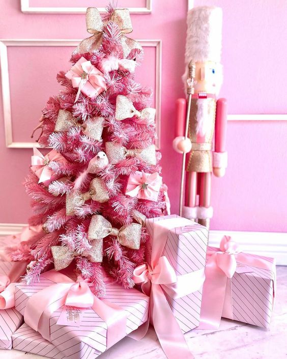 a tabletop pink Christmas tree decorated with gift boxes and bows looks cool and cute and can be used anywhere