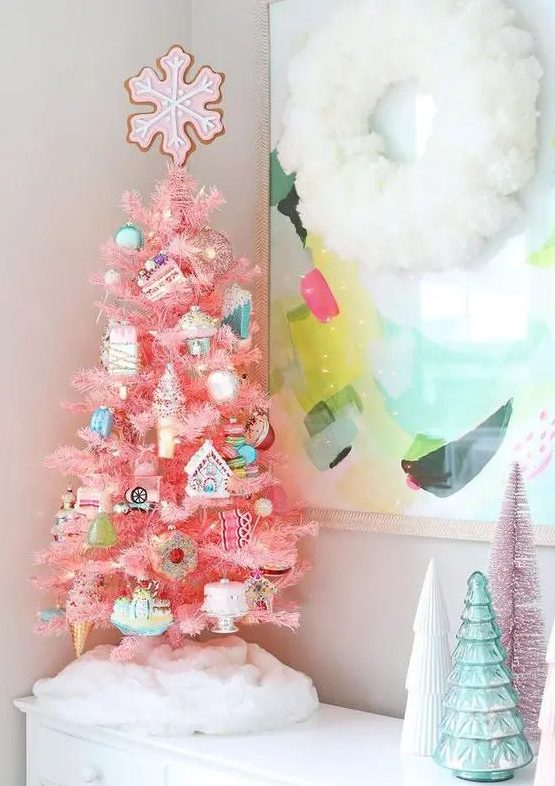 a tabletop pink Christmas tree with lights, pastel and silver food-themed ornaments and a pink snowflake on top
