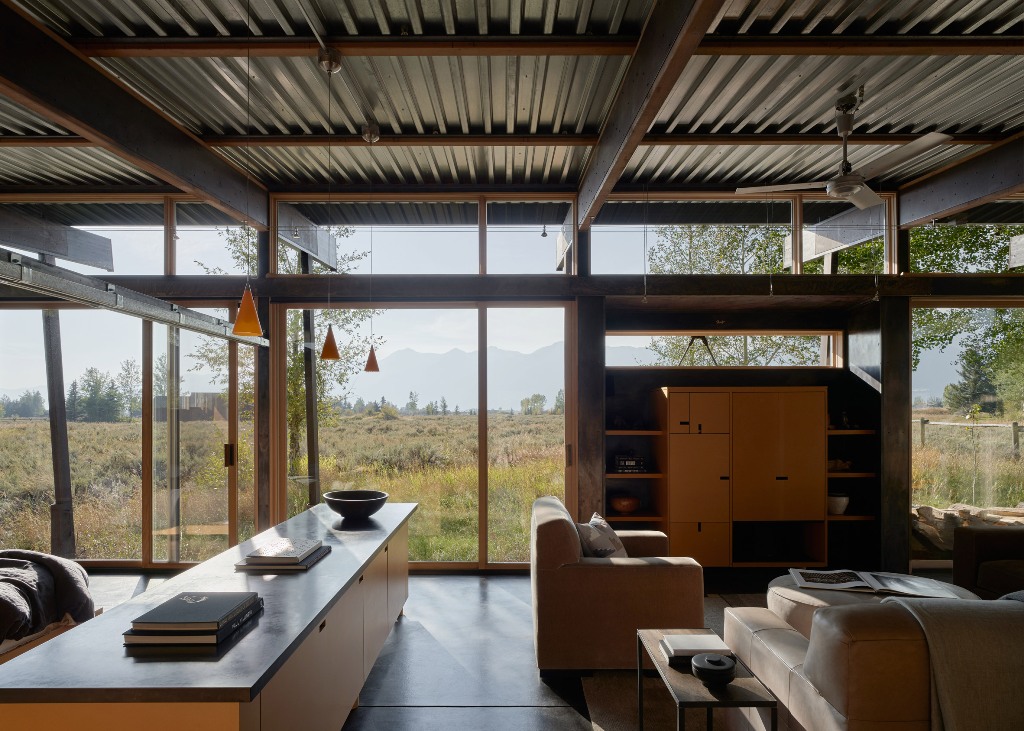 Most of the walls are glazed for light and views, and the furniture is contemporary and mid-century modern