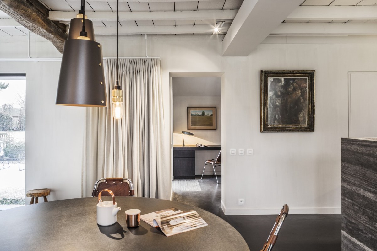 The dining space is done with a concrete table, leather and metal chairs and cool pendant lamps