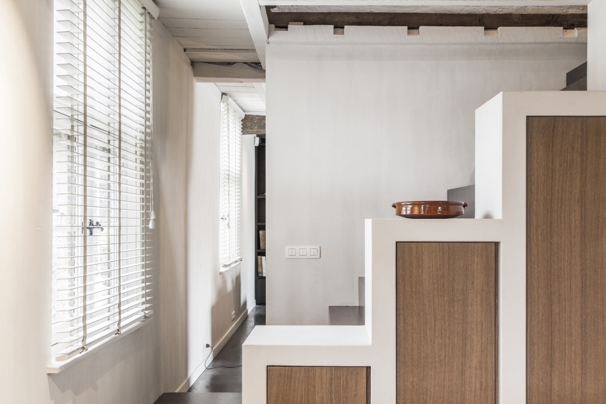 The staircase is divided from the rest of the space with a storage unit, too