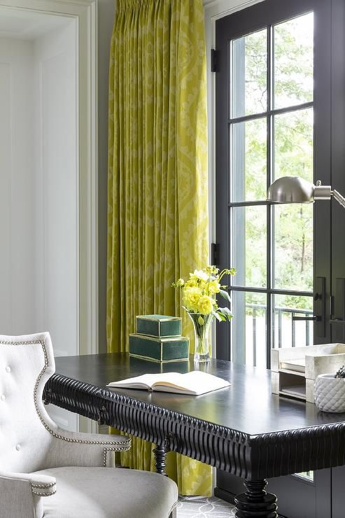 a black spindle desk paired with a light gray velvet chair and yellow damask curtains for a very chic and exquisite home office