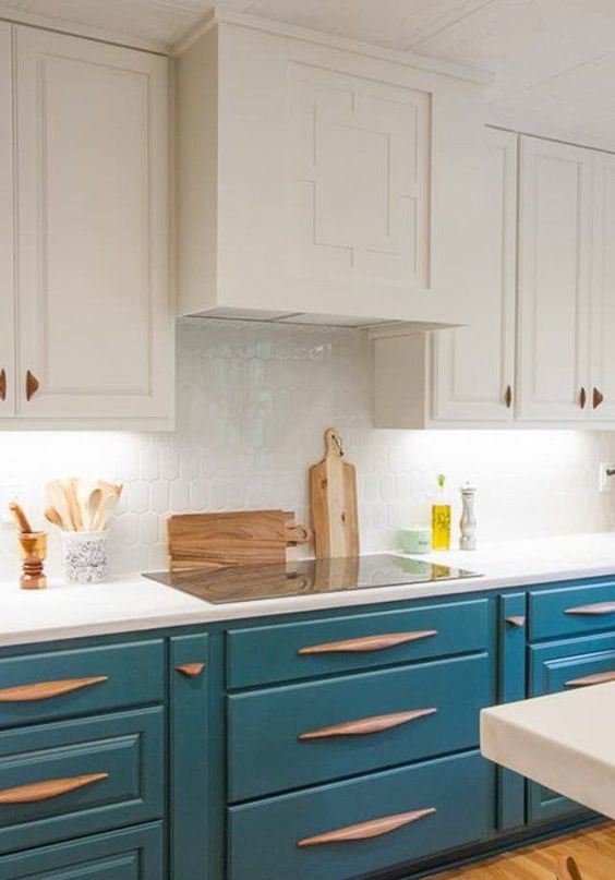 a white and peacock blue kitchen is a very eye-catchy idea, unusual wooden handles add to the space and make it wow