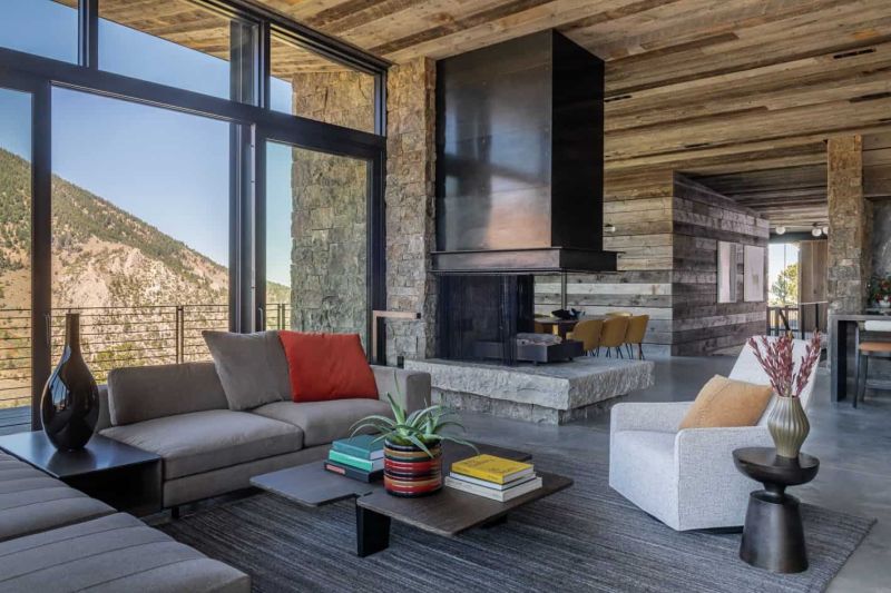 06 The living room shows off grey and neutral furniture, a fireplace with a dark metal hood and a stone base