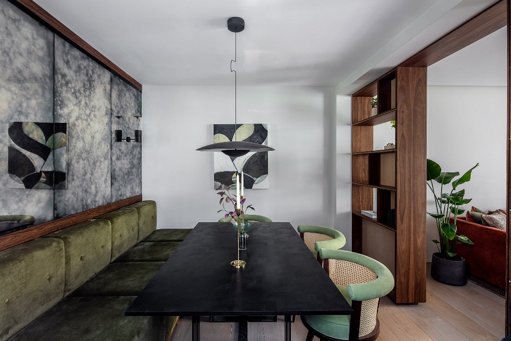 08 The dining space shows off a banquette seating, a black stone table and some catchy green chairs