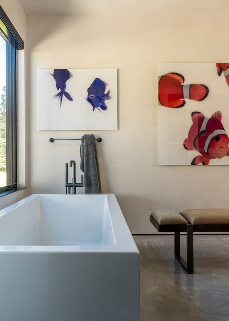 The bathroom is neutral but it's accented with bright and colorful fish artworks for fun