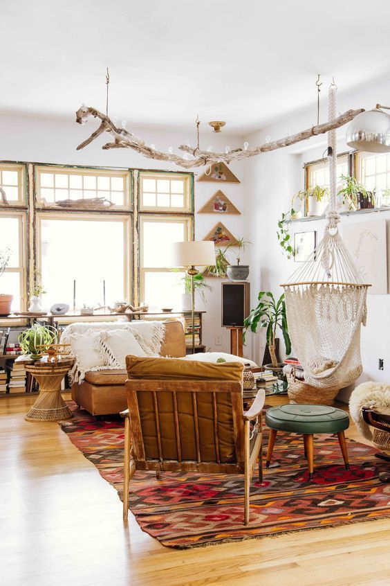a global style living room in earthy tones, driftwood lights, a colorful rug, leather furniture and creative art