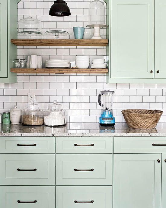 a modern sage green kitchen with chic cabinetry, a white subway tile backsplash with black grout and grey stone countertops