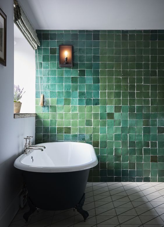 a catchy and refined bathroom with a statement wall done with tiles of various shades of green