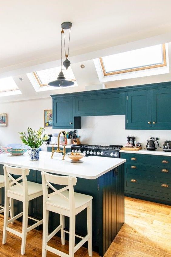 25 a lovely teal kitchen with a white backsplash and countertops, a matching kitchen island with white countertops and a backsplash