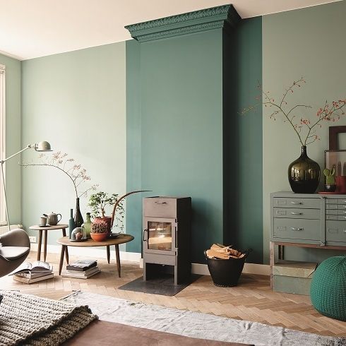 a stylish Japandi living room with olive green walls and a dark green accent, simple and modern furniture