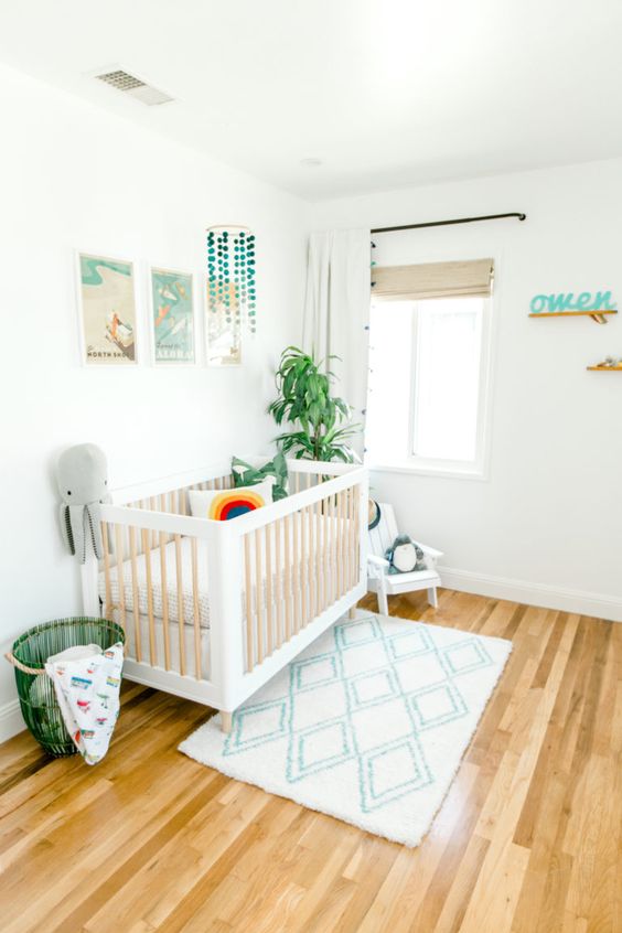 a beach boho nursery with neutral furniture, a pretty gallery wall, some art and bedding and printed textiles