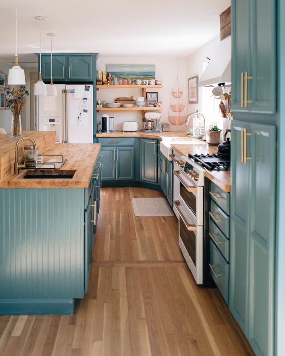 31 a stylish farmhouse kitchen in teal, with butcherblock countertops, a white backsplash and gold fixtures