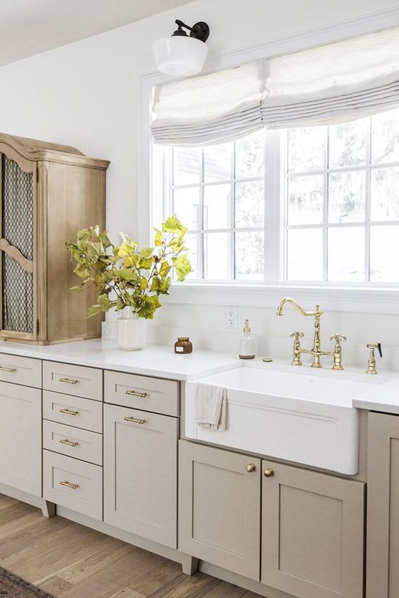 a chic greige farmhouse kitchen looks very warm and welcoming, it's cozy and very beautiful