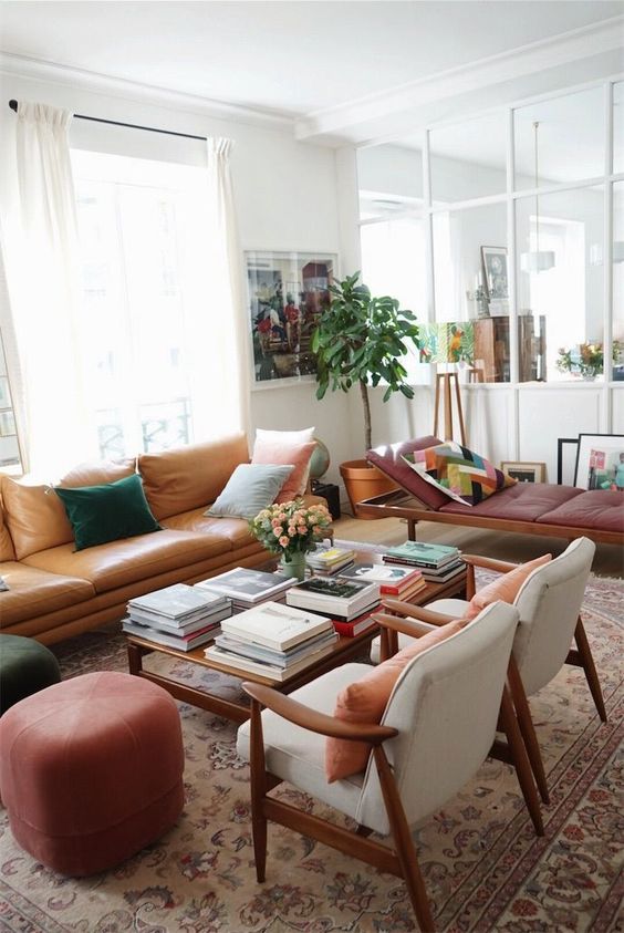 a neutral living room done with warm-colored furniture, with pretty pillows, artworks and potted plants