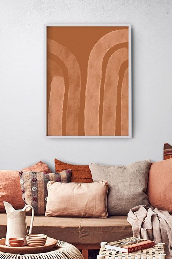 a welcoming warm-toned living room with a brown sofa and terracotta pillows, blankets and accessories