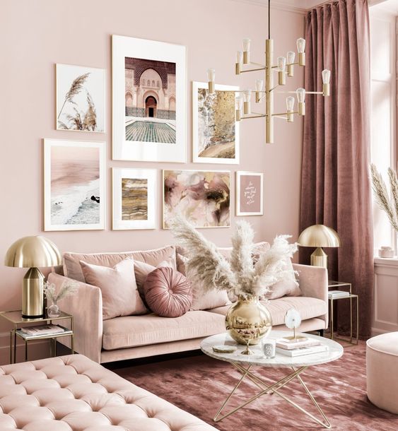 a refined monochromatic pink living room with elegant furniture, a gold chandelier, pampas grass and a cool gallery wall