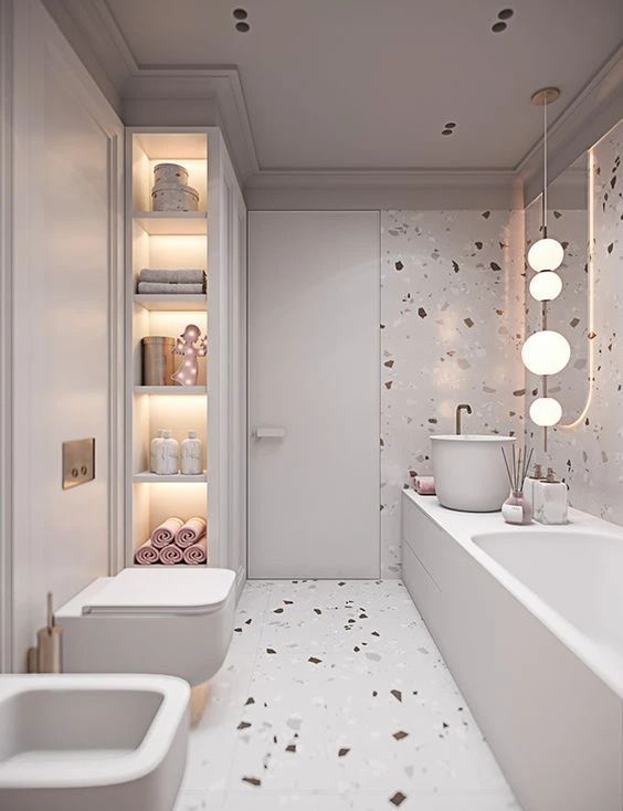 a neutral bathroom with neutral terrazzo walls and a floor, built-in lights and pink and blush touches