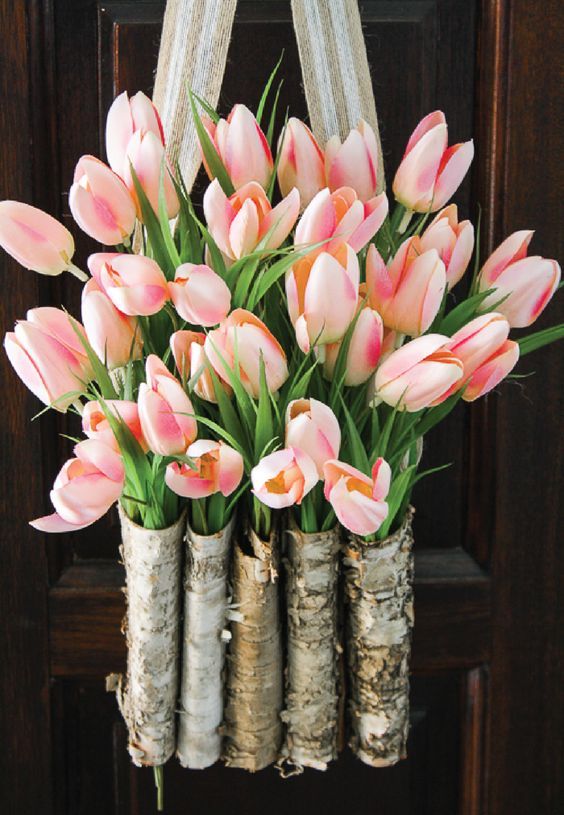 a creative front door decoration of birch vases and pink tulips is a beautiful alternative to a usual wreath