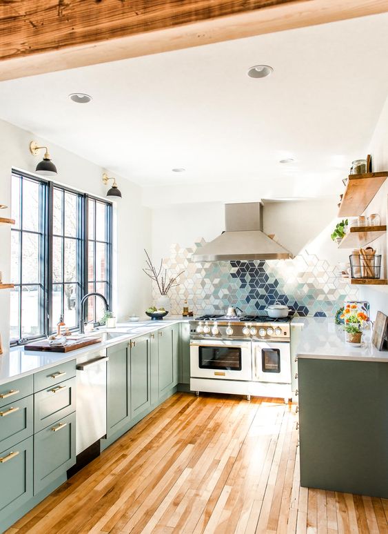 a beautiful green U shaped kitchen with white countertops and a geometric ombre tile backsplash and wooden beams