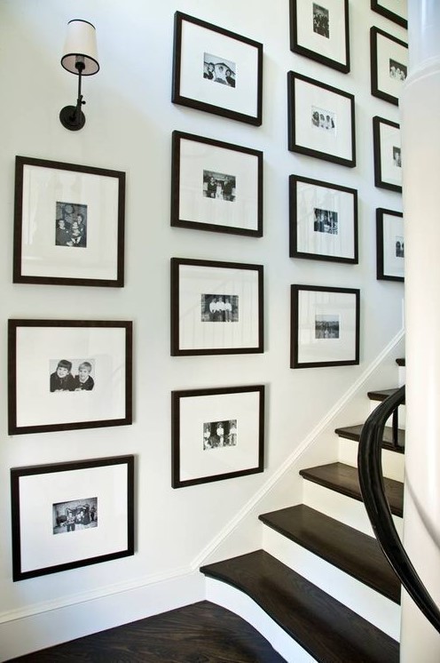 a black and white grid gallery wall with black and white family pics is a cool and stylish idea that brings ultimate elegance