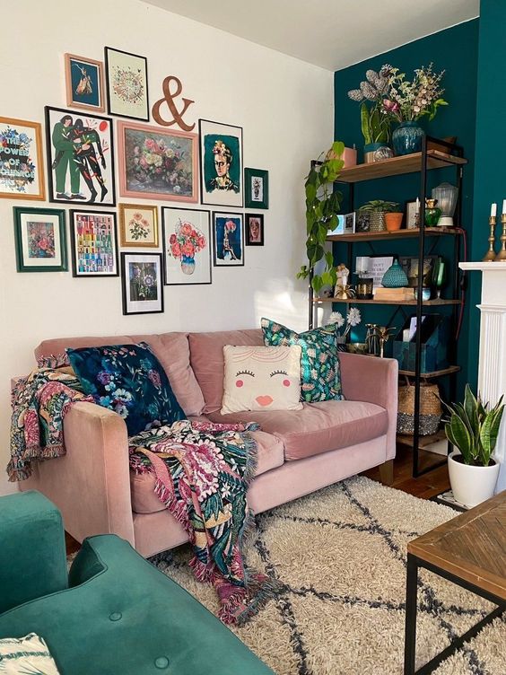 a bright free form gallery wall with mismatching frames and colorful artworks including floral ones plus textiles with the same patterns