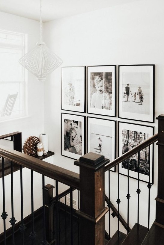 a chic black and white grid gallery wall with matching black frames and white matting adds style and a modern feel to the space