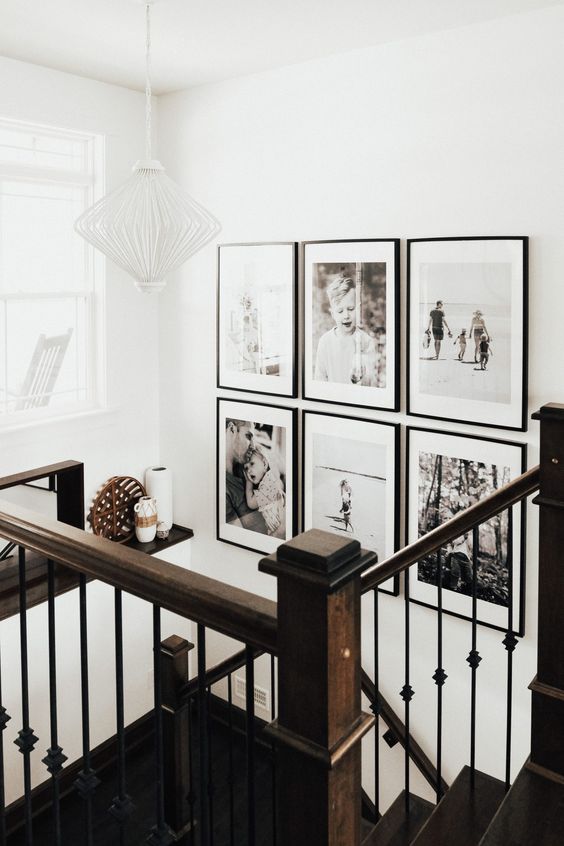 a chic black and white grid gallery wall with matchingblack frames and white matting adds style and a modern fele to the space