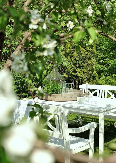 a chic dining space under the trees - vintage white garden furniture for a lovely and cool look