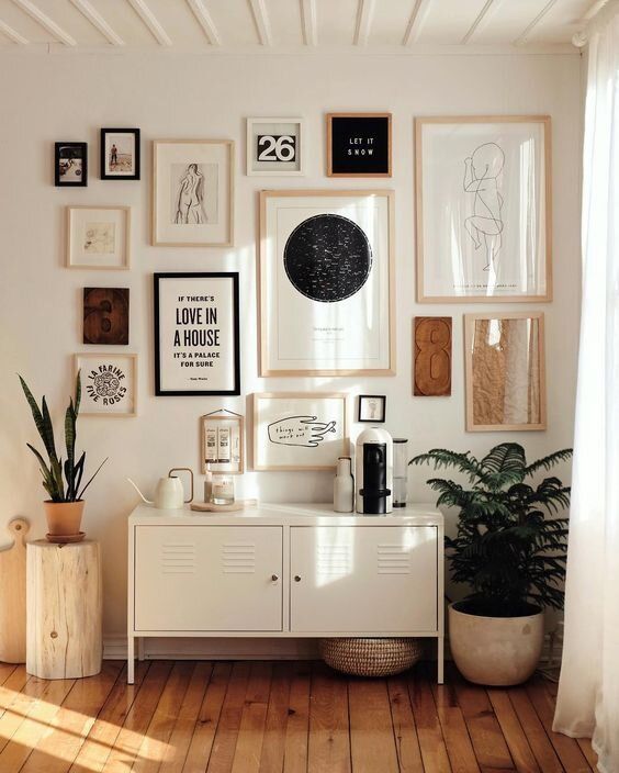a chic gallery wall with mismatching neutral and black frames, with various creative art in neutrals and black
